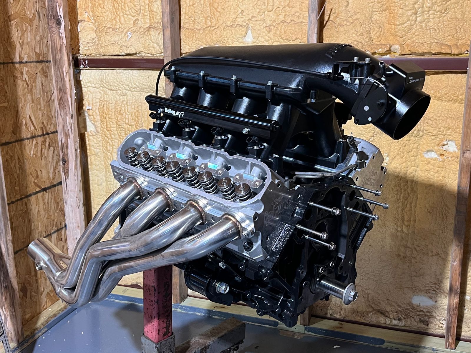 An LS with long tube headers on the stand at Red’s Speed Shop